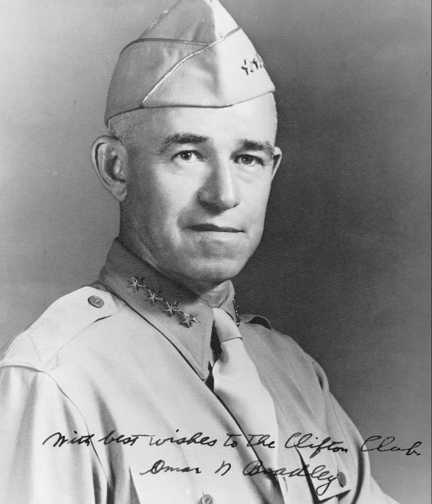 A black and white portrait of a senior military officer in uniform with a signed inscription.