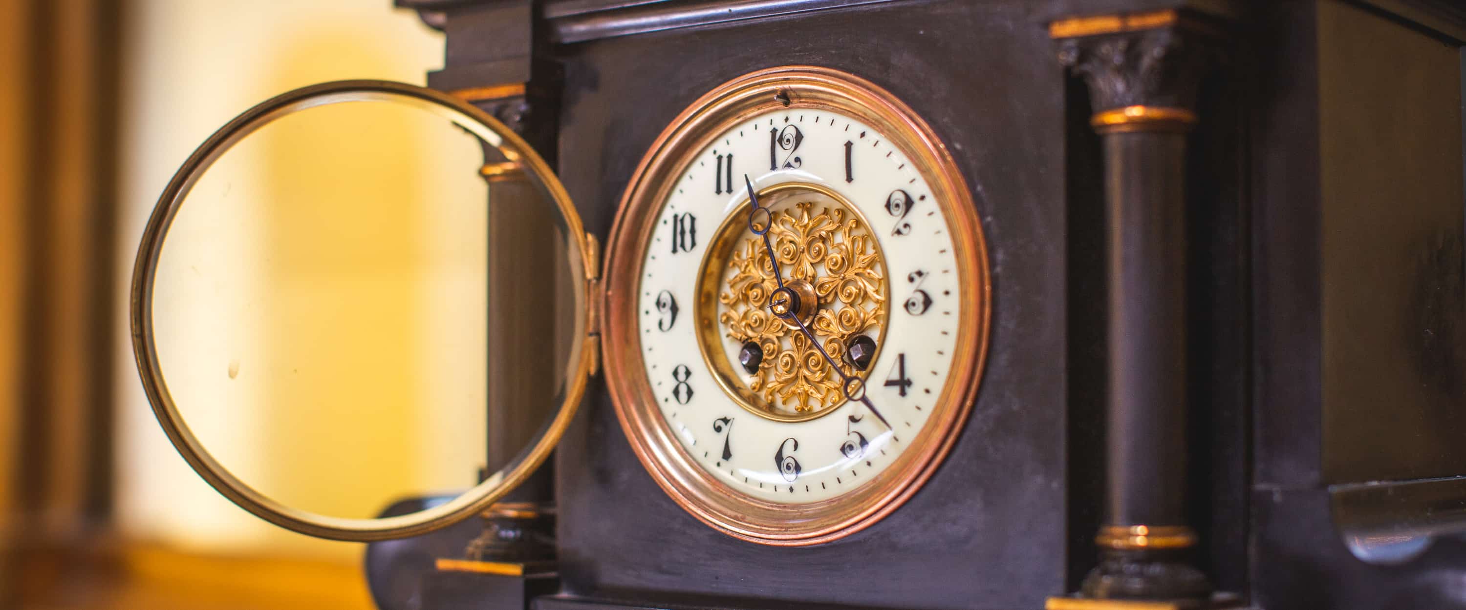 Vintage open-faced mantle clock with ornate details.